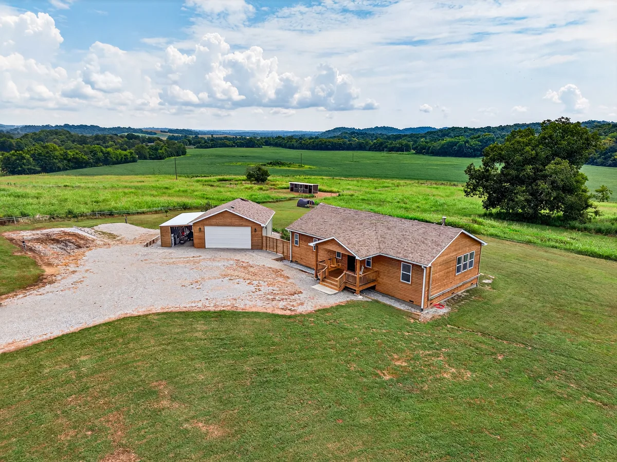 Aerial view showing a Pulaski home, detached garage, and surrounding land